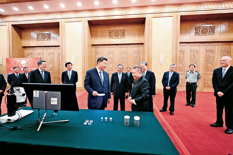 2024年9月23日，黨和國家領(lǐng)導(dǎo)人習(xí)近平、李強、趙樂際、王滬寧、蔡奇、丁薛祥、李希等在人民大會堂接見探月工程嫦娥六號任務(wù)參研參試人員代表并參觀月球樣品和探月工程成果展覽。這是習(xí)近平等參觀月球樣品和探月工程成果展覽。 新華社記者 謝環(huán)馳/攝